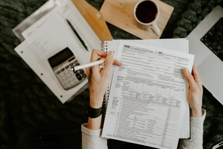 Person reviewing documents with a calculator to prepare a compliance audit
